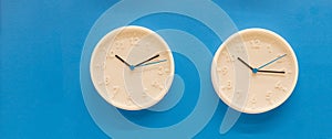 White big analogue plain wall clock on trendy pastel blue background. copy space, time management concept and opening or