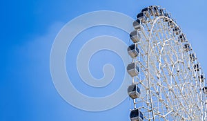 white big Ferris wheel on background clear blue sky in fair in summer with copy space