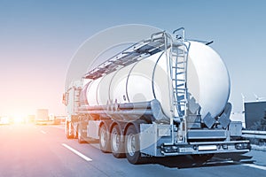 White big modern tanker shipment cargo commercial semi trailer truck moving fast on motorway road city urban suburb