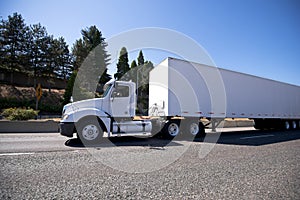 White big rig day cab semi truck and dry van trailer for local d