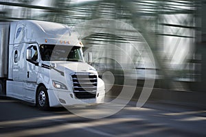 White big rig semi truck with chrome grille transporting goods i