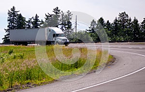 White big rig semi truck with long trailer turning on highway ex