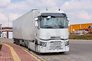 White big truck parked on the side of the lot on road. Cargo transportation