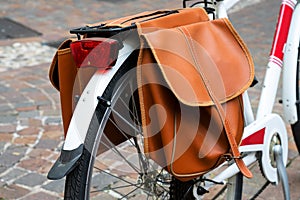 White bike with brown leather saddlebag