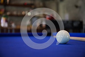 White Billiard ball on blue pool table