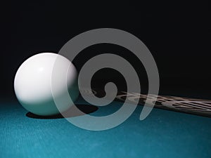 White billiard ball a cue on a table. Black background