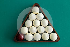 White billiard balls and cue ball for Russian billiards, in a triangle on the table.