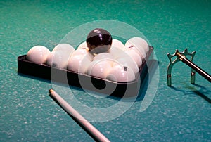 White billiard balls folded in a triangle on a green gaming table