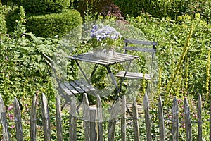 White bistro table and chairs in a lush garden