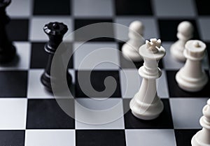 White and black chess figures on board. Chess game position. Black and white king.