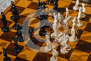 White and black chess pieces stand on the board during a chess game