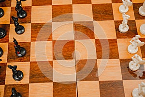White and black chess pieces stand on the board during a chess game