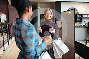 White and black females with shopping bags in mall