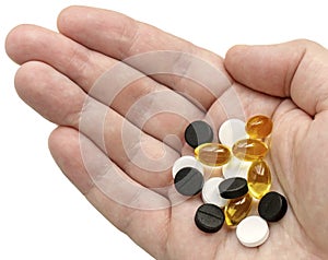 White, black and golden clear pills in your palm