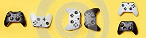 White and black many joystick gamepad game console isolated on yellow colourful trendy background. Computer gaming competition