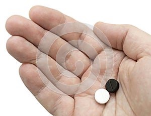 White and black pills in your palm