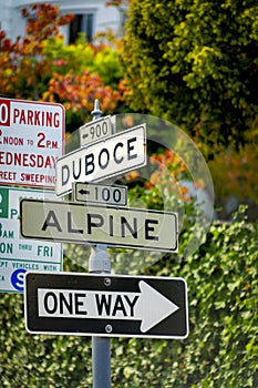 White and black road sign that says Duboce and Apline and One Way in the city or in an urban area
