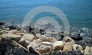 White and black sea rocks on the seaside and glitter shiny water