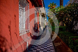 White and black tile sidewalk under a trees shadows in the Barrio Yungay in Santiago, capital of Chile