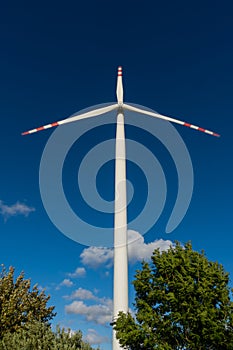 White blades of a wind turbine against the background of a navy blue sky. photo
