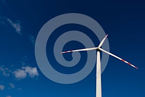 White blades of a wind turbine against the background of a navy blue sky. photo