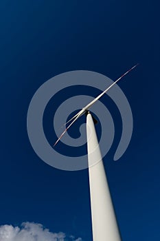 White blades of a wind turbine against the background of a navy blue sky. photo