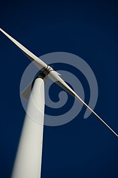 White blades of a wind turbine against the background of a navy blue sky. photo