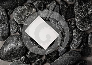 White blank  business card on black stones or galet ,concept of zen spa or sauna branding photo