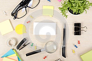 White blank business card. Office table desk with set of colorful supplies, cup, pen, pencils, flower, notes, cards on