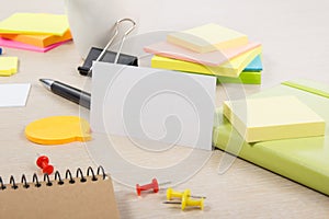 White blank business card. Office table desk with set of colorful supplies, cup, pen, pencils, flower, notes, cards on