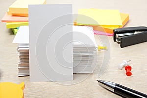 White blank business card. Office table desk with set of colorful supplies, cup, pen, pencils, flower, notes, cards on