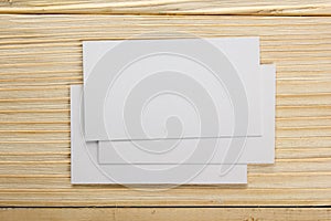 White blank business visit card, gift, ticket, pass, present close up on wooden background. Copy space Blank corporate identity p