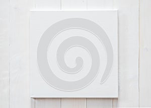White blank canvas mockup square size on white wood wall for arts painting and photo hanging