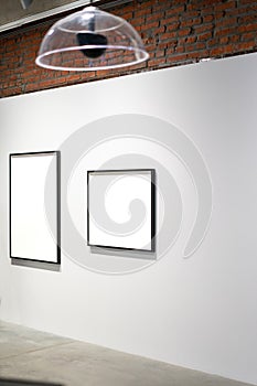 White blank canvas posters on the wall in modern bright art gallery.