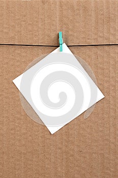 White blank card on rope on a brown cardboard background. Creati