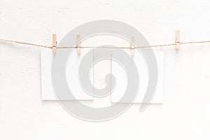 White blank cards on rope, light wall background