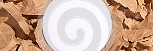 White blank circle mockup on pieces of torn brown craft paper background banner