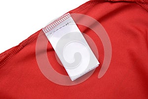 White blank clothing tag label on shirt fabric texture background