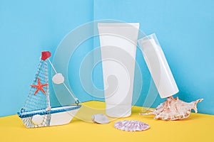 White blank cosmetic tube, bottle with sunscreen, sun cream, moisturizing lotion, seashells and small boat on blue, yellow