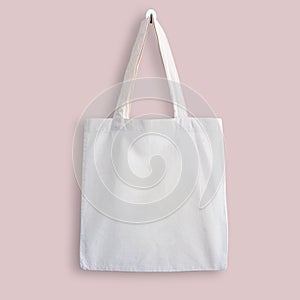 White blank cotton eco tote bag, design mockup. Shopping bag hanging on wall