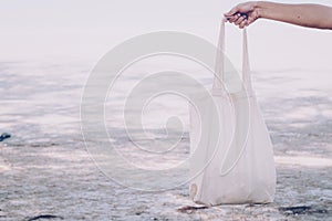 White blank cotton eco tote. Design mockup. Holding blank canvas tote bag, design mockup