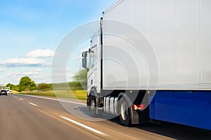 White blank modern delivery big shipment cargo commercial semi trailer truck moving fast on motorway road city urban