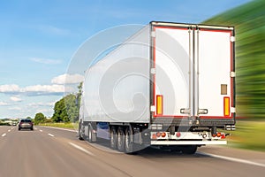 White blank modern delivery big shipment cargo commercial semi trailer truck moving fast on motorway road city urban