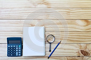 White blank notebook, textbook with calculator and pencil on tab