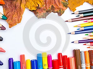 White blank page, colorful pencils, markers and autumn leaves mock-up composition Back to school concept top view