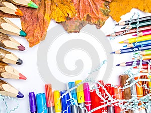 White blank page, colorful pencils, markers and autumn leaves mock-up composition Back to school concept top view