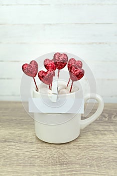 White blank paper clipped on coffee cup with glitter red heart