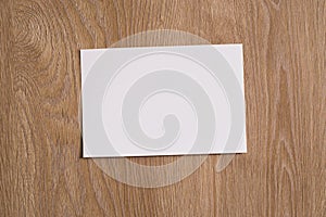 White blank piece of paper on a wooden texture background