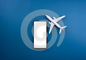 White blank screen mockup on smartphone with white clean airplane model toy.