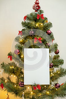 White blank sheet of paper against the background of the Christmas tree and the fireplace